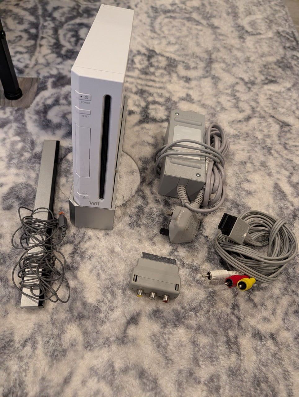 Wii gaming console and accessories on a patterned carpet