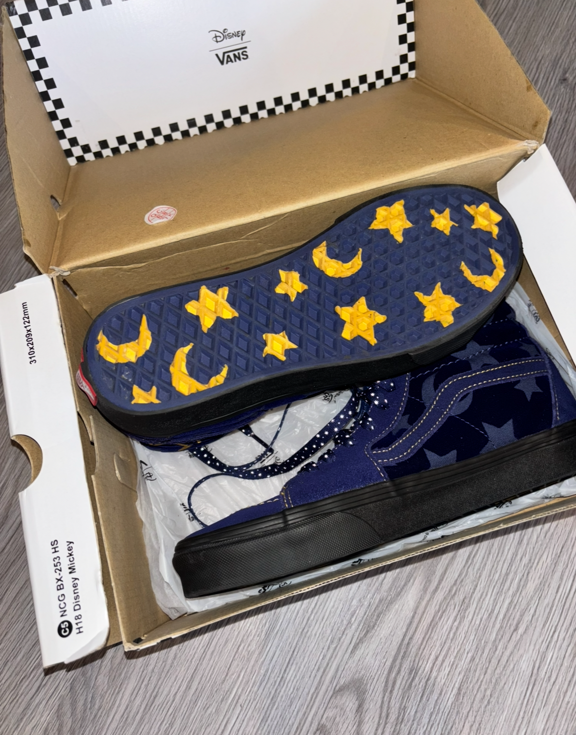 Vans shoe with star and moon patterned insole in an open box.