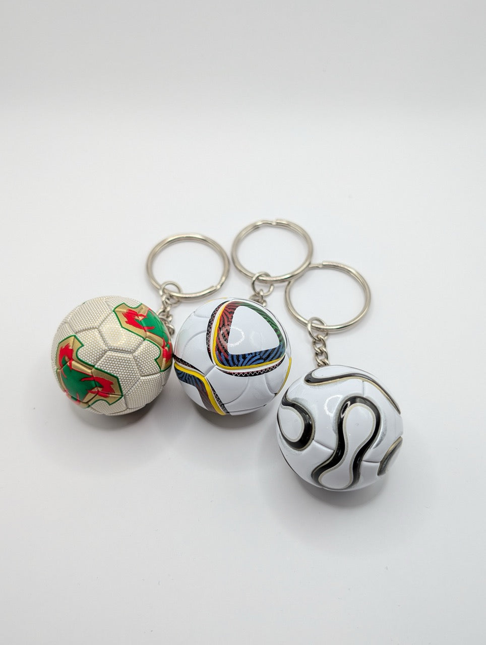 Three soccer ball keychains on a white background