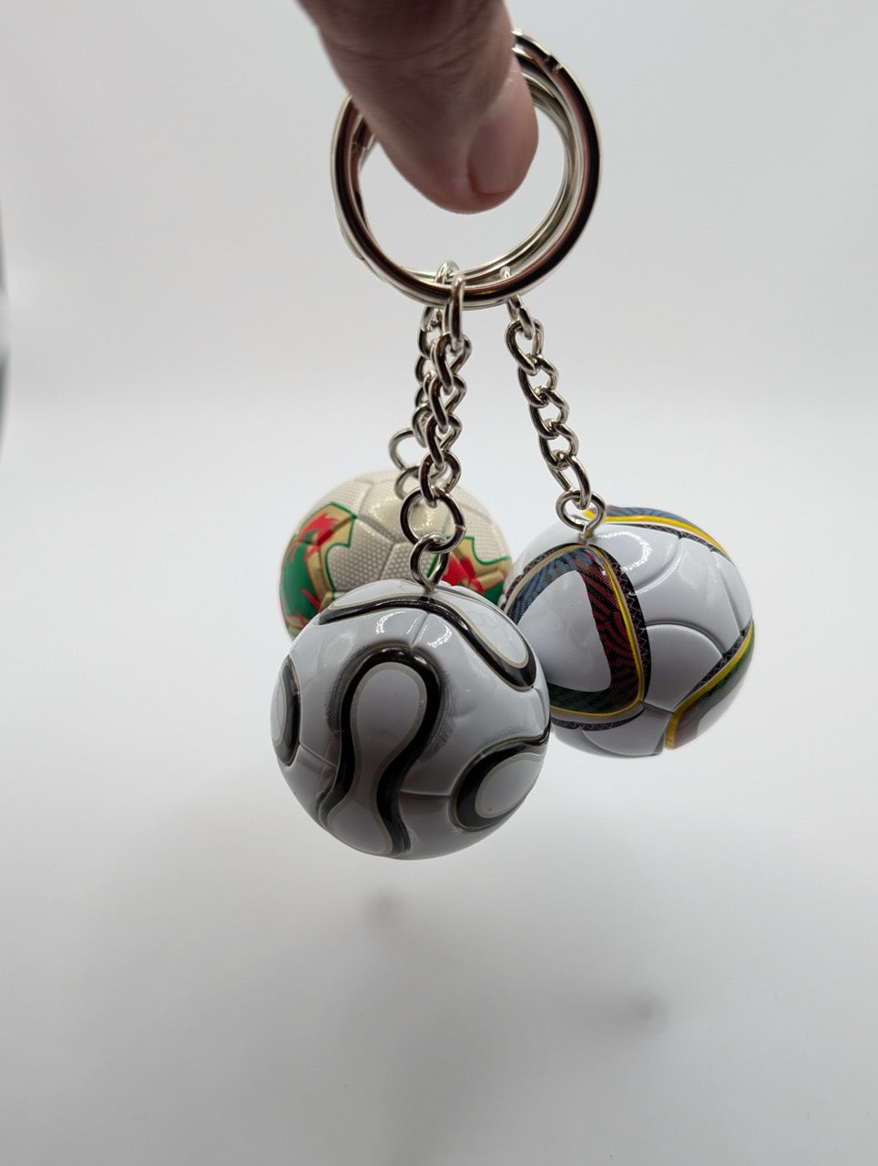 Keychain with soccer ball charms on a plain background