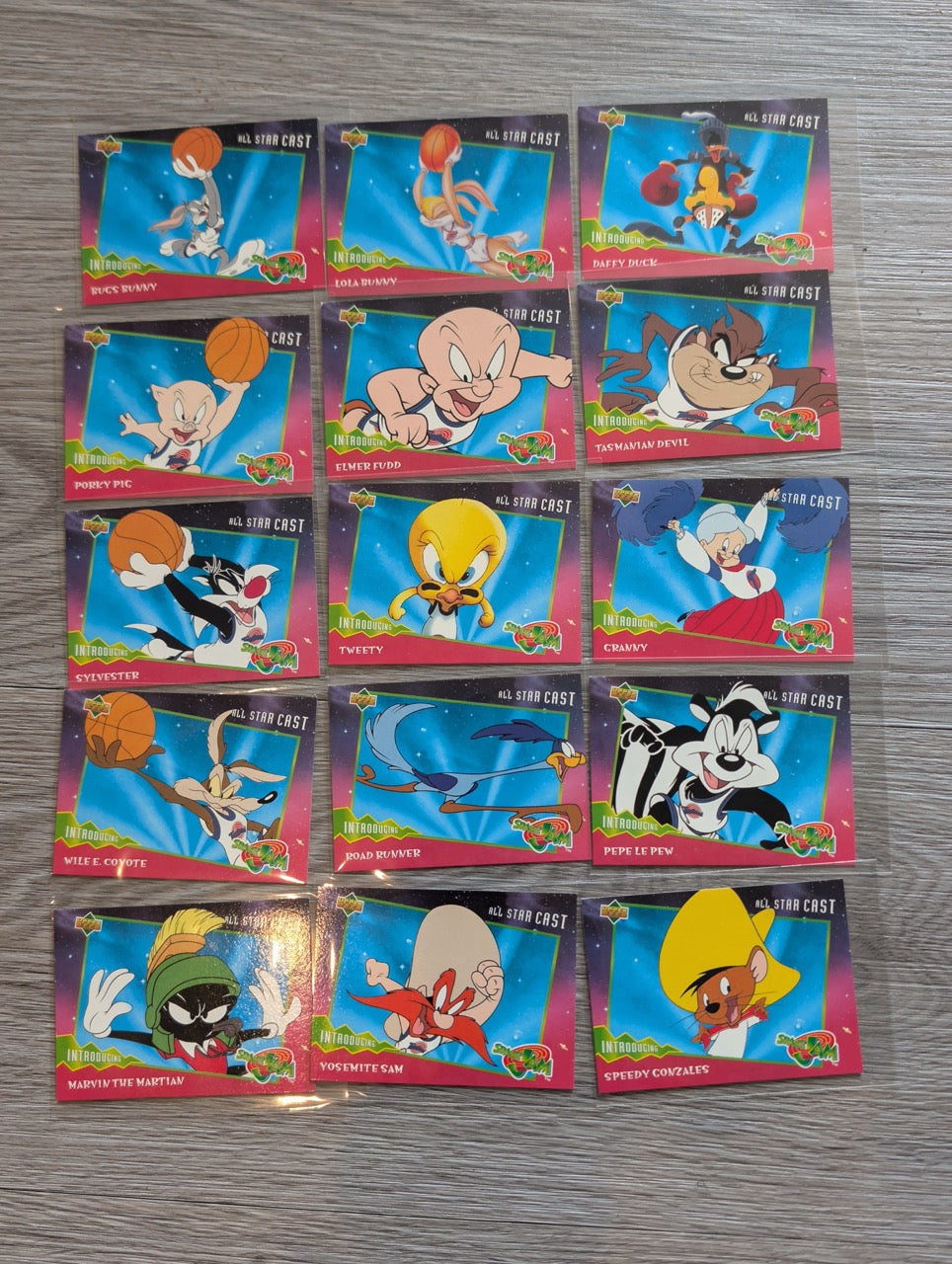 Collection of animated character trading cards on a gray surface
