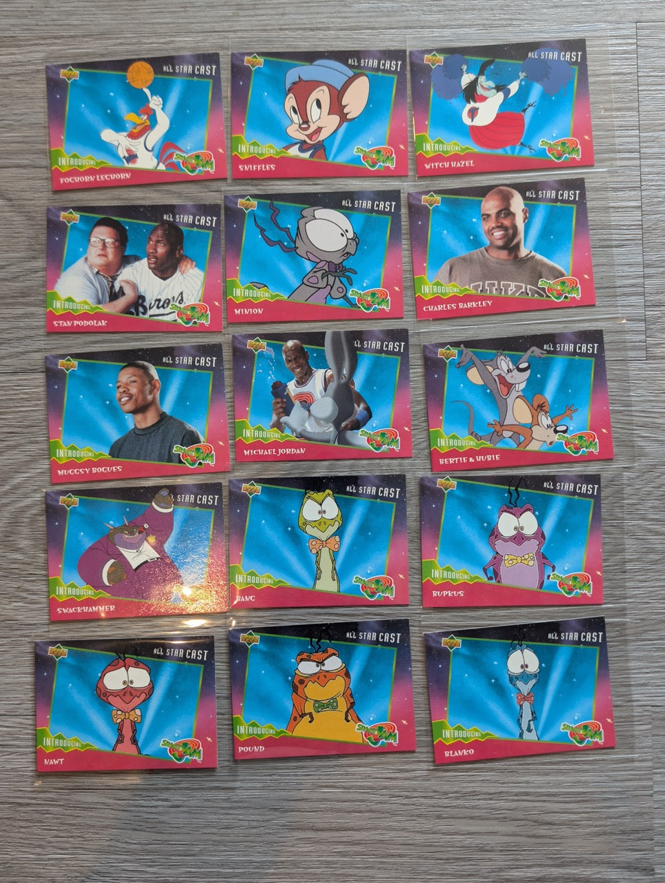 Collection of trading cards with colorful designs on a gray surface